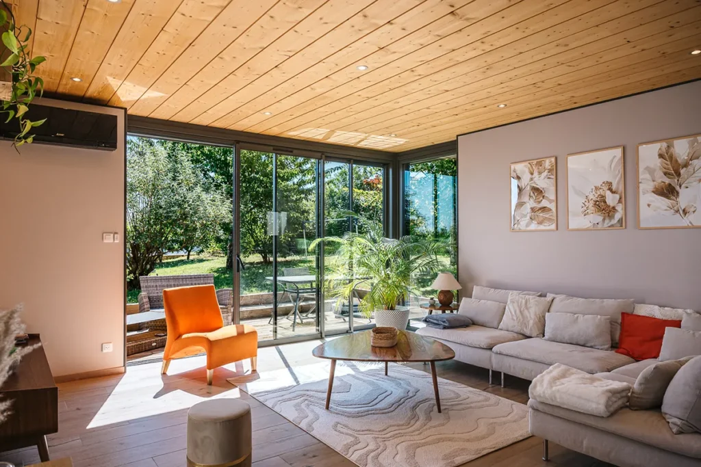 Intérieur d’une extension de 20 m² avec plafond bois et larges ouvertures vitrées