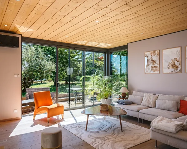 Intérieur d’une extension de 20 m² avec plafond bois et larges ouvertures vitrées