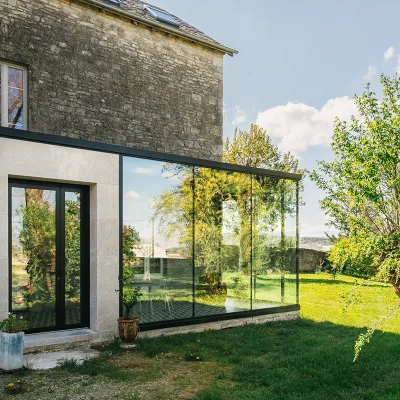 Extension minimaliste avec toit végétalisé sur batisse ancienne