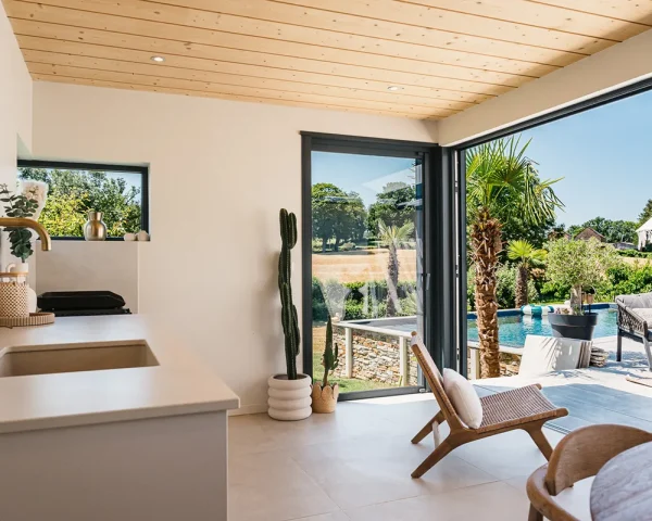 Intérieur lumineux d’un pool-house de 21 m² avec porte accordéon vitrée
